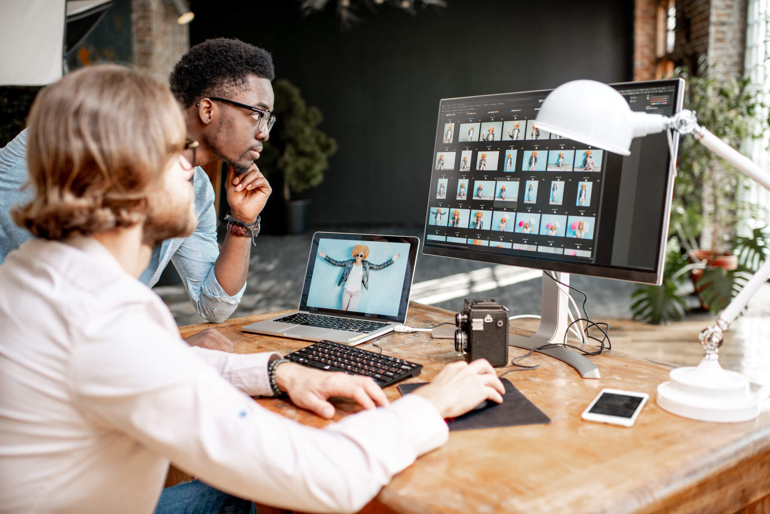 Two designers working at a workstation on web design Mississauga businesses trust