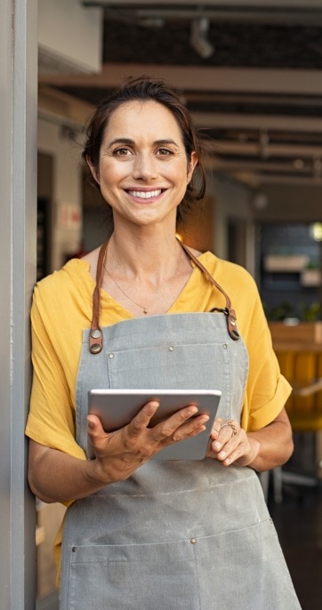 Smiling woman with tablet in apron IT support Milton